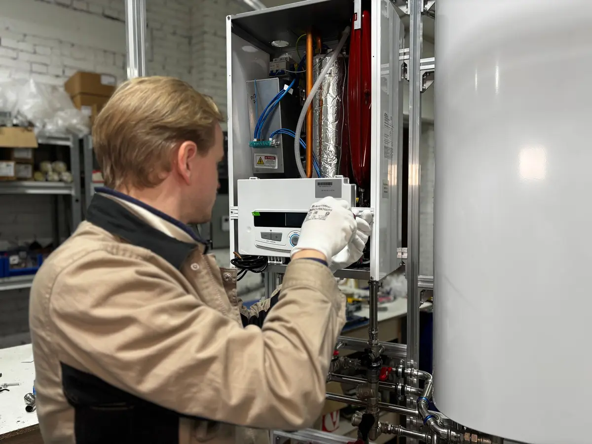 Engineer checking the internals of a wall-mounted boiler