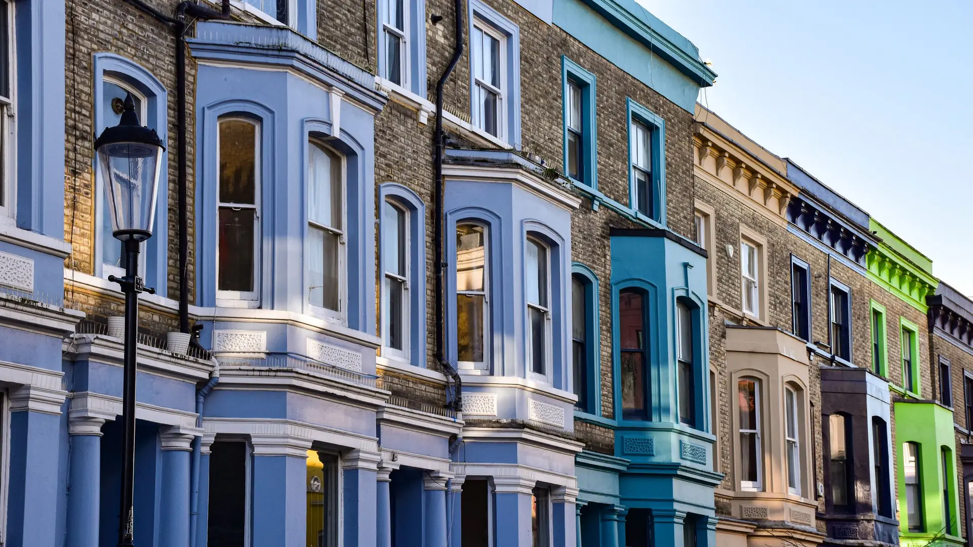 A row of colourful painted terraced houses on a London street