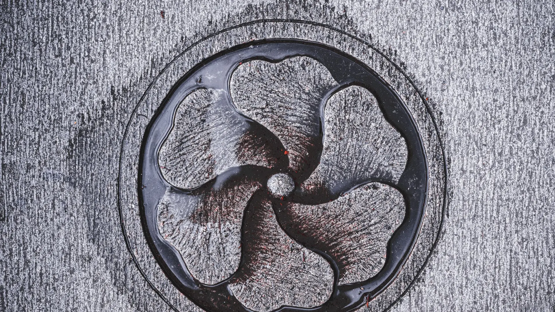 A decorative round metal drain grate