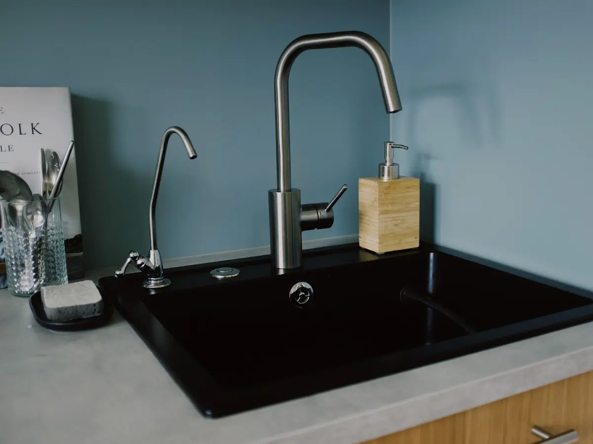 Brushed steel kitchen tap over a black sink