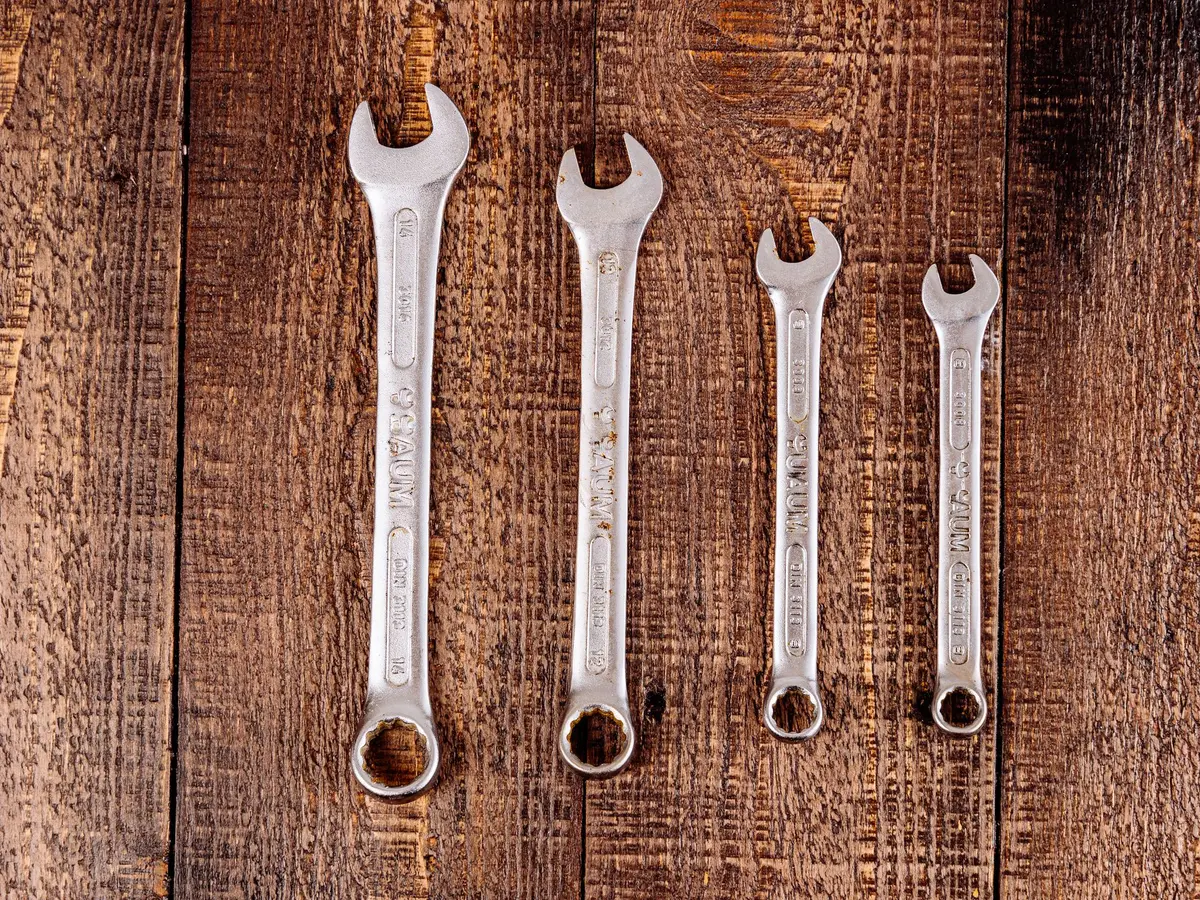 A row of spanners laid out on a timber bench